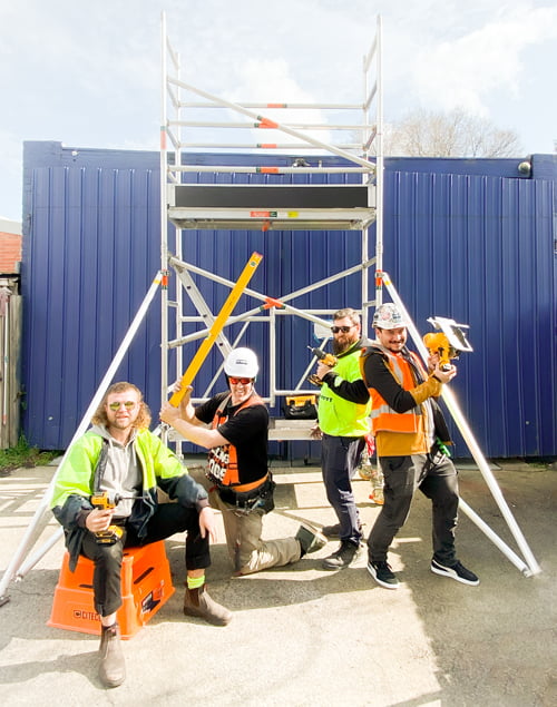 Four members of the coop posing with their tools and high vis vests.